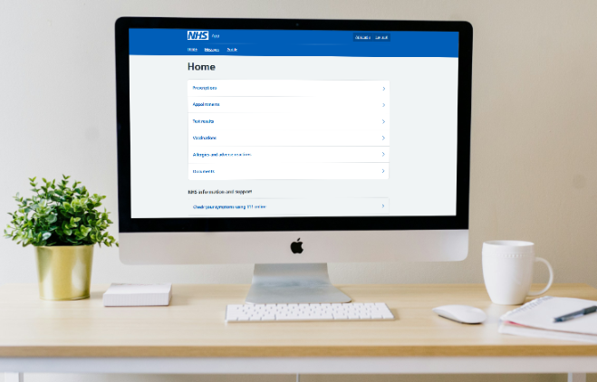 Image of an iMac on a desk showing the NHS app online homepage